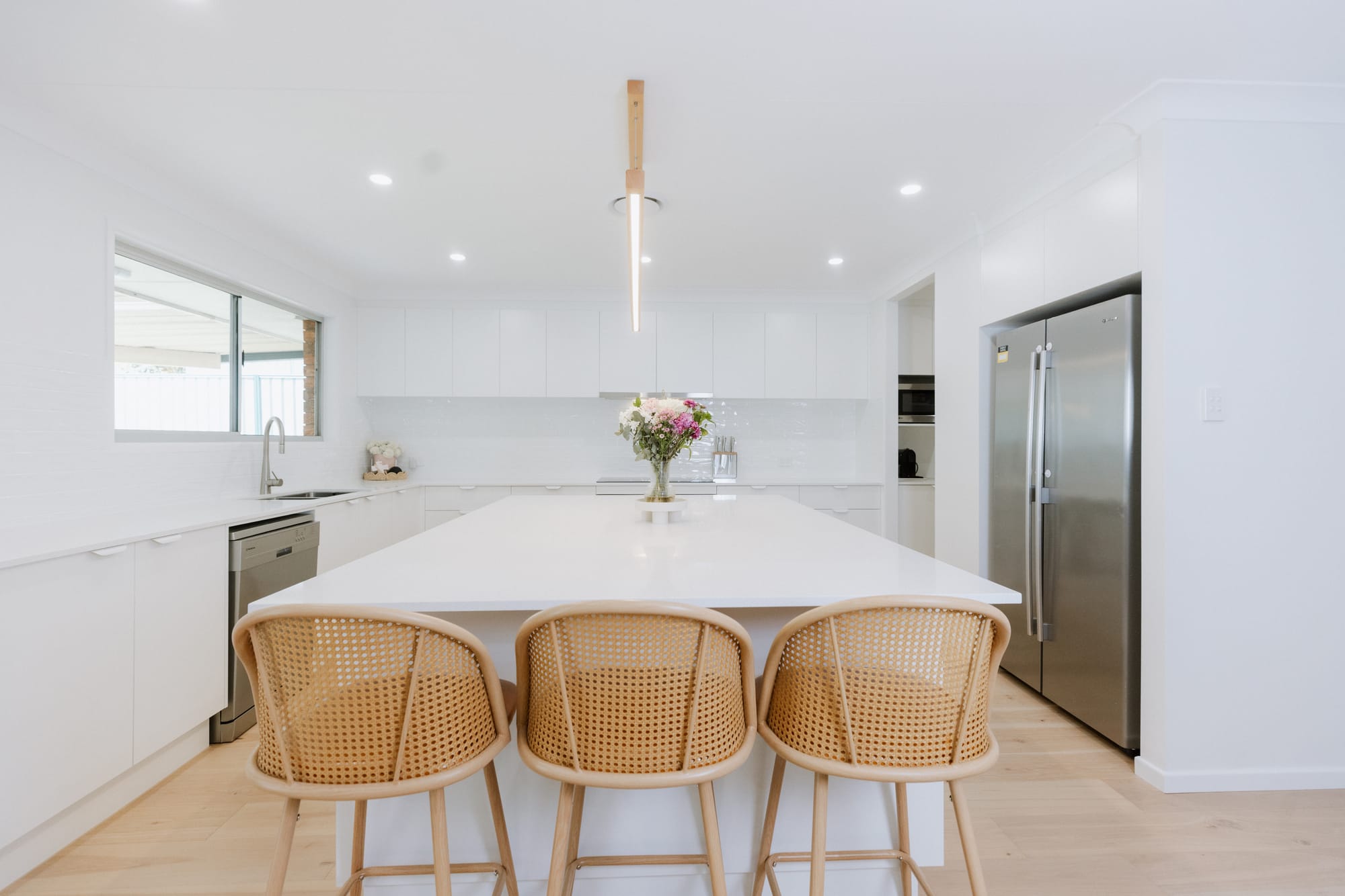 Bright modern kitchen with island and rattan stools