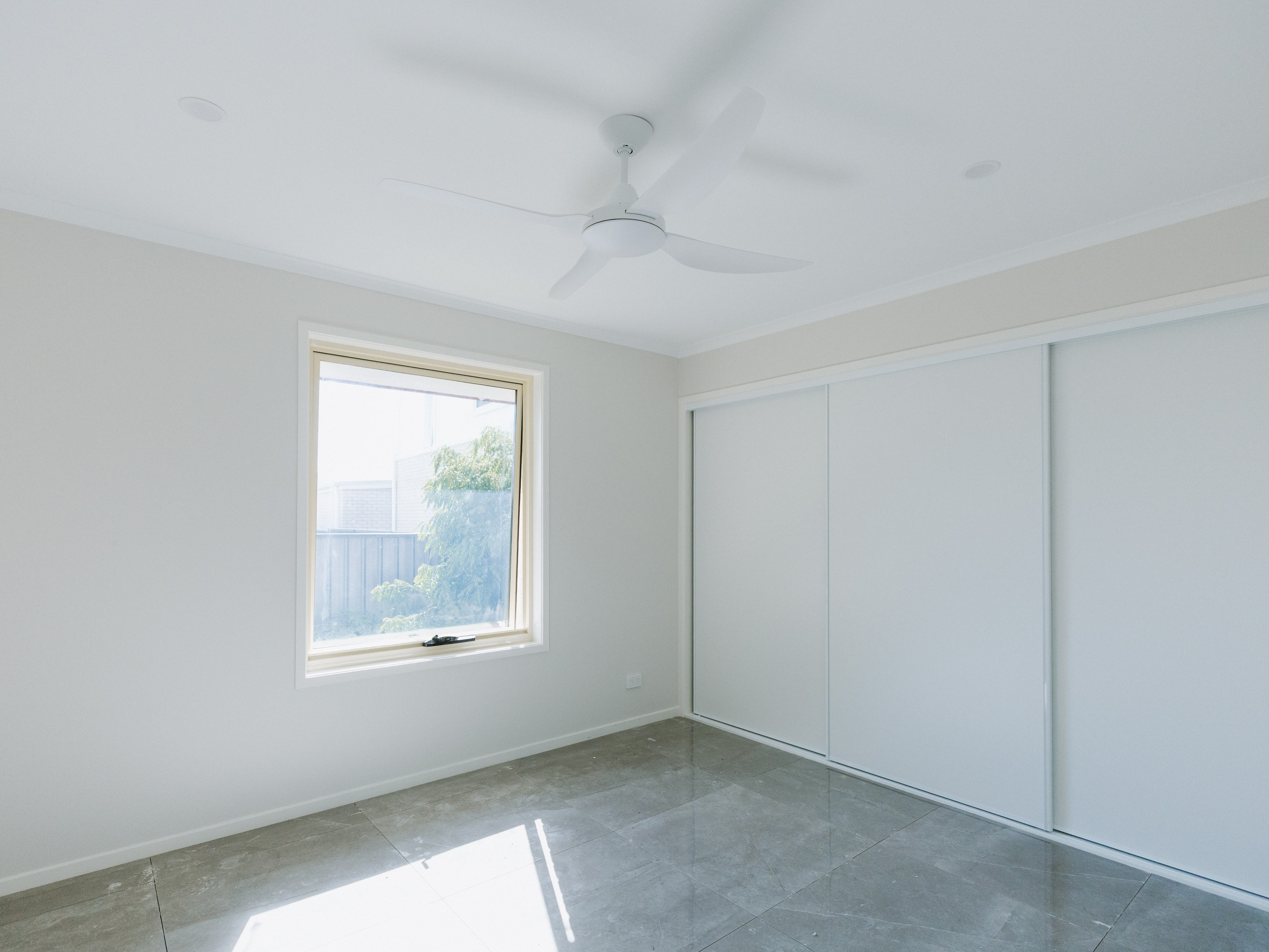 New master bedroom in house extension, Alexandra Hills Brisbane — tiled floor, built-in wardrobe and ceiling fan